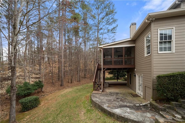 view of yard featuring a sunroom, a patio area, stairway, and french doors