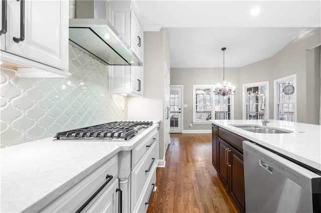 kitchen featuring dark wood-style floors, custom exhaust hood, stainless steel appliances, white cabinetry, and a sink