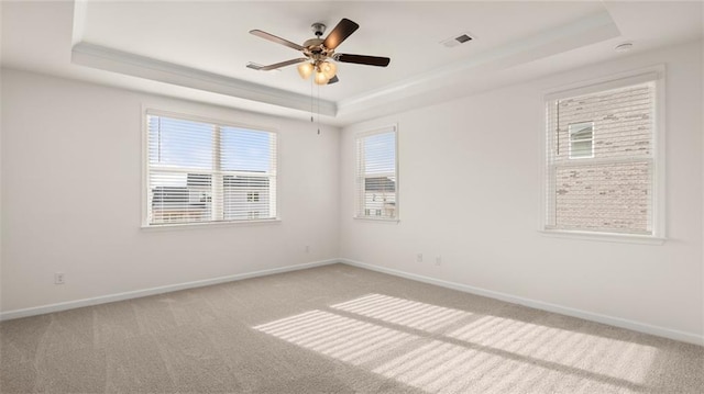 unfurnished room with light carpet, a tray ceiling, and ceiling fan