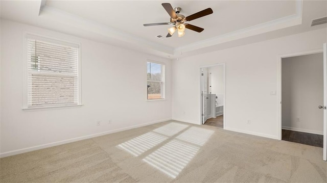 spare room with light carpet, ceiling fan, and a tray ceiling