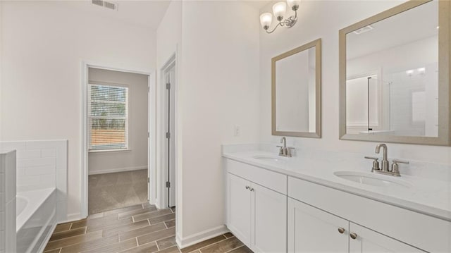 bathroom with a tub to relax in and vanity