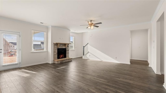 unfurnished living room featuring ornamental molding, dark wood-type flooring, ceiling fan, and a fireplace