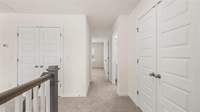 hallway featuring light colored carpet