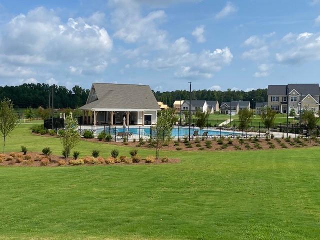 view of property's community featuring a pool and a lawn