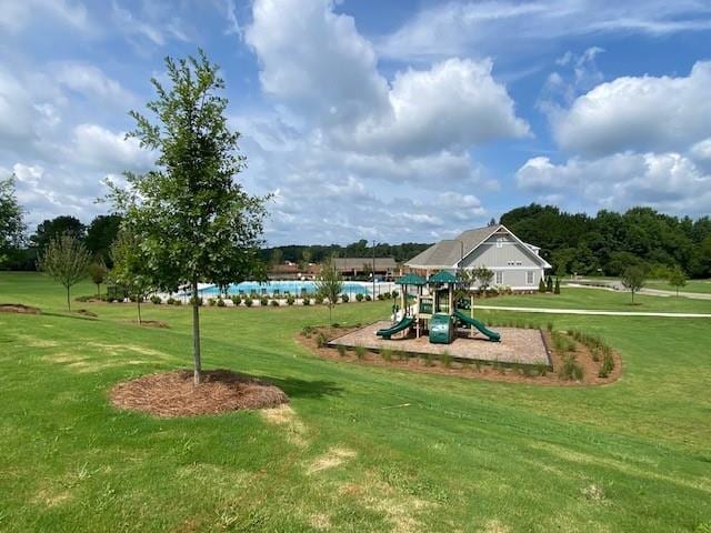 view of property's community with a playground and a lawn