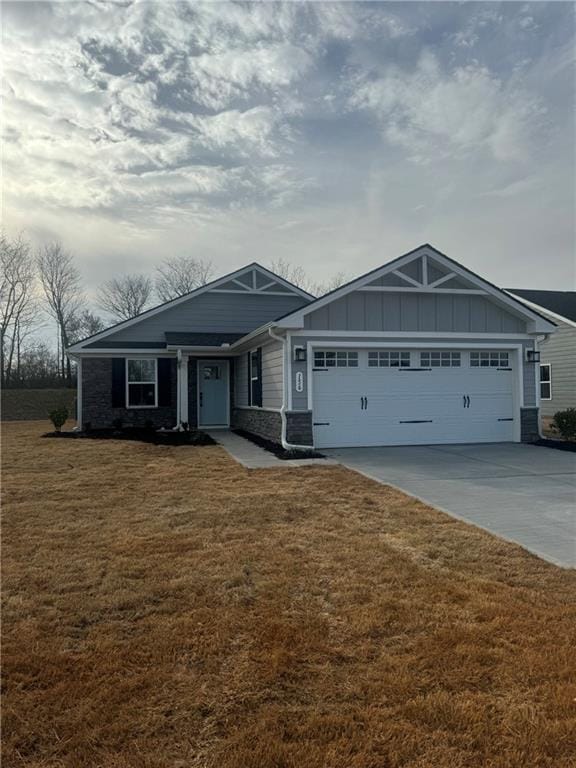 craftsman inspired home with a front yard, concrete driveway, a garage, stone siding, and board and batten siding