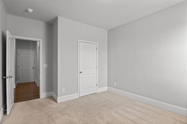 unfurnished bedroom featuring carpet floors and baseboards