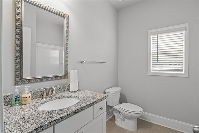 bathroom featuring tile patterned floors, vanity, toilet, and baseboards