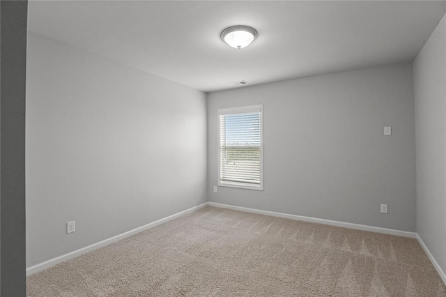 carpeted empty room featuring baseboards and visible vents