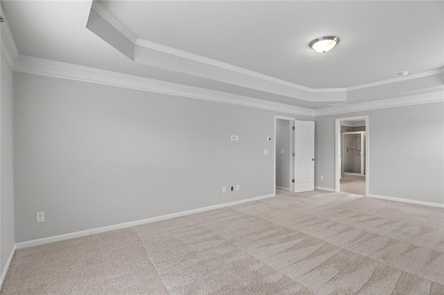 spare room featuring carpet, crown molding, a tray ceiling, and baseboards