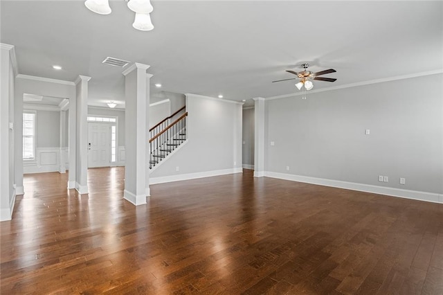 unfurnished living room featuring crown molding, stairway, dark wood finished floors, and ornate columns