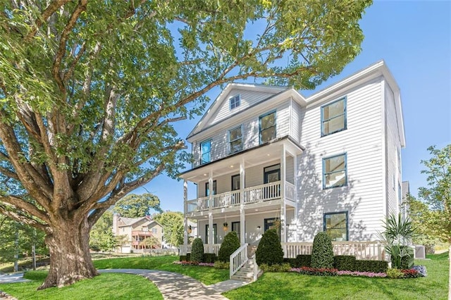 view of front of house featuring a balcony, a front yard, and a porch