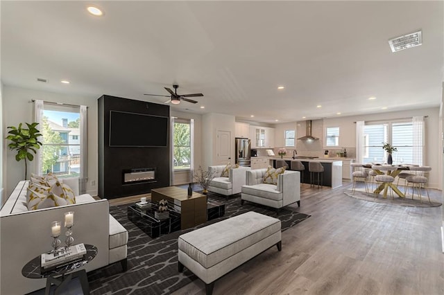 living room featuring a fireplace, wood-type flooring, and plenty of natural light