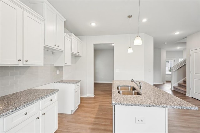 350 Lanier Cir, Woodstock, GA 30189 - kitchen featuring light stone countertops, light wood finished floors, decorative backsplash, white cabinets, and recessed lighting