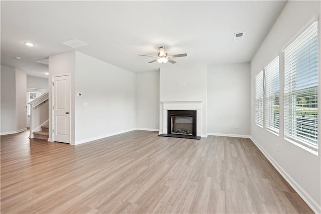 350 Lanier Cir, Woodstock, GA 30189 - unfurnished living room with ceiling fan, light wood finished floors, a fireplace with raised hearth, stairs, and recessed lighting