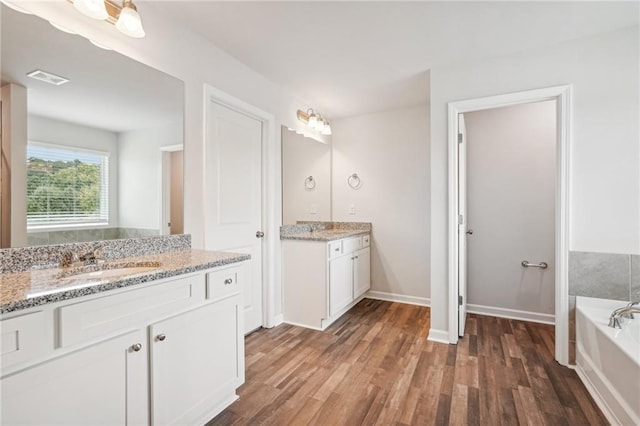 350 Lanier Cir, Woodstock, GA 30189 - full bathroom featuring wood finished floors, two vanities, and a garden tub