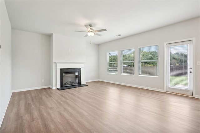 350 Lanier Cir, Woodstock, GA 30189 - unfurnished living room with light wood-style flooring, healthy amount of natural light, a fireplace with raised hearth, and ceiling fan