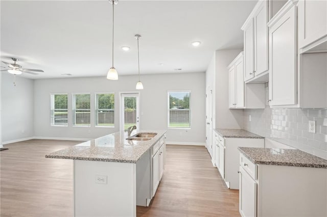 350 Lanier Cir, Woodstock, GA 30189 - kitchen featuring light wood-style floors, light stone countertops, healthy amount of natural light, and recessed lighting