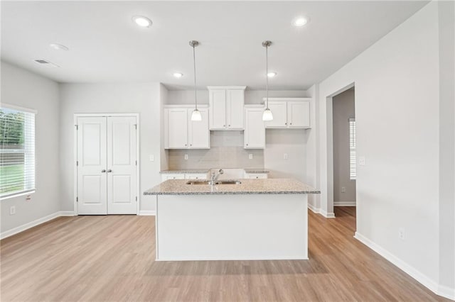 350 Lanier Cir, Woodstock, GA 30189 - kitchen with light wood-type flooring, a center island with sink, backsplash, white cabinetry, and recessed lighting