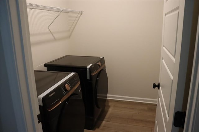 laundry area featuring dark wood-type flooring and washing machine and clothes dryer