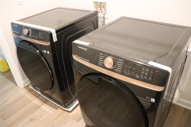 washroom featuring light hardwood / wood-style floors and washing machine and clothes dryer