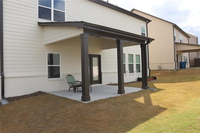 back of house featuring a patio area and a lawn