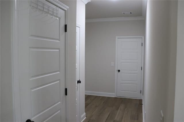 hallway with dark wood-type flooring and ornamental molding