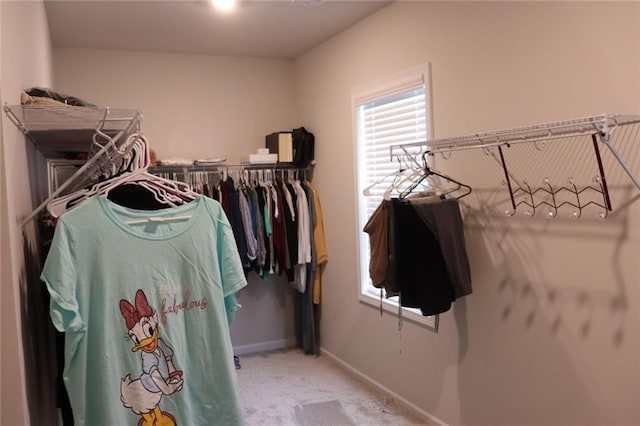 walk in closet with light colored carpet