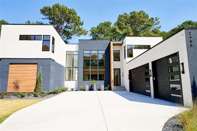 modern home with driveway, a garage, and stucco siding