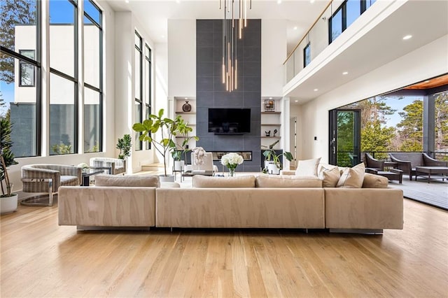 living area with light wood-type flooring and a towering ceiling