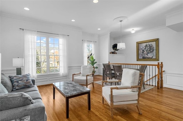 sitting room with crown molding and light wood-type flooring