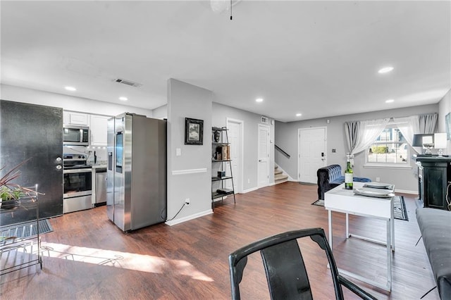 kitchen with white cabinets, stainless steel appliances, and dark wood-type flooring