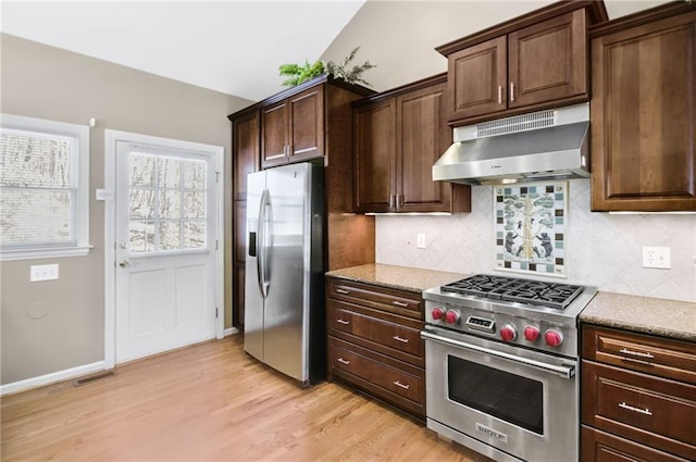 71 Yellow Root Dr, Big Canoe, GA 30143 - kitchen with stainless steel appliances, under cabinet range hood, light wood-style flooring, backsplash, and light stone countertops