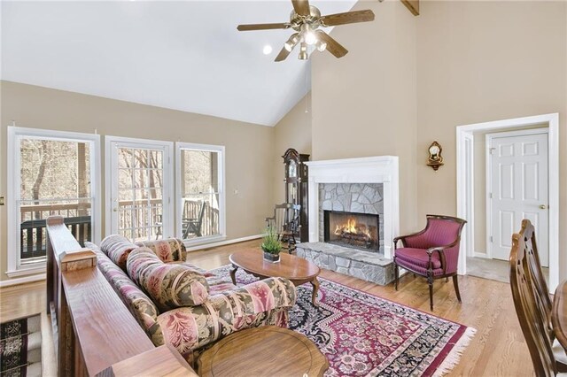 71 Yellow Root Dr, Big Canoe, GA 30143 - living area featuring a stone fireplace, high vaulted ceiling, light wood-type flooring, a ceiling fan, and baseboards