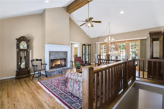 71 Yellow Root Dr, Big Canoe, GA 30143 - living area with ceiling fan, beam ceiling, wood finished floors, a stone fireplace, and baseboards