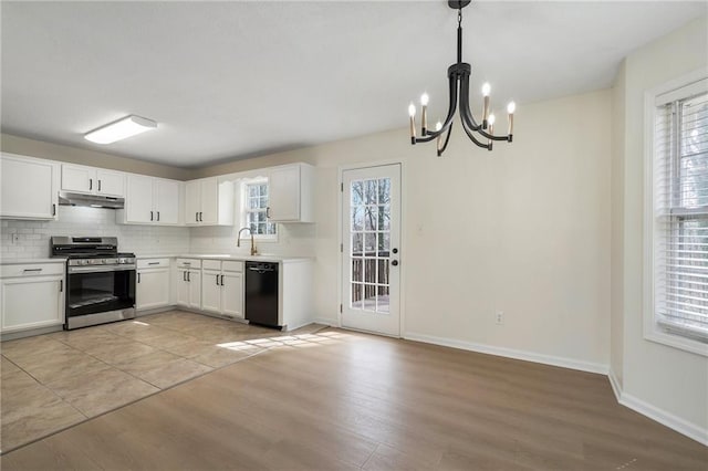 kitchen with stainless steel gas range oven, under cabinet range hood, dishwasher, decorative backsplash, and a notable chandelier