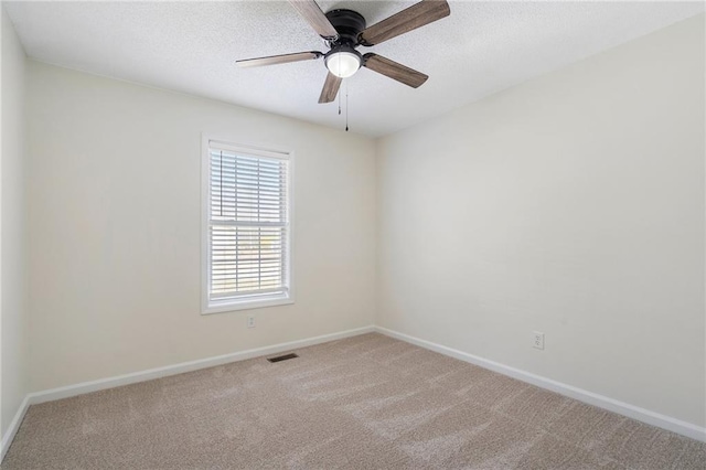 unfurnished room featuring visible vents, a textured ceiling, baseboards, and carpet