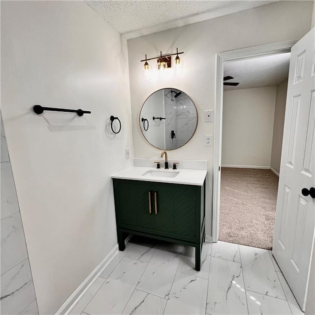 bathroom with marble finish floor, a textured ceiling, vanity, and baseboards