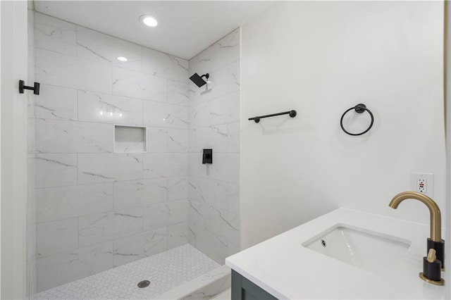 full bath featuring recessed lighting, vanity, and a tile shower