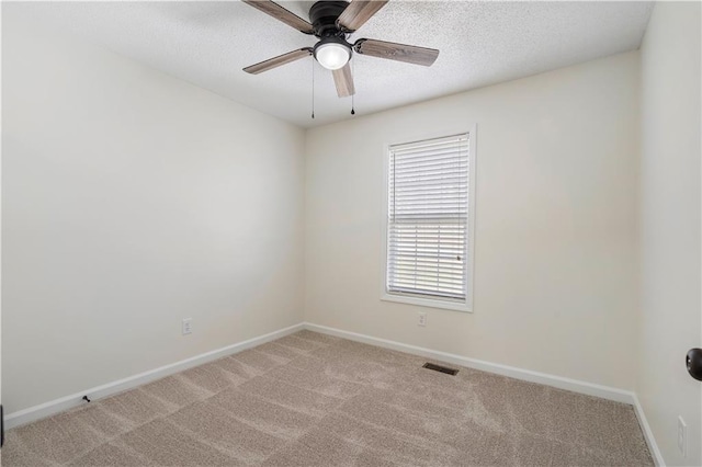 unfurnished room with visible vents, baseboards, light colored carpet, a textured ceiling, and a ceiling fan