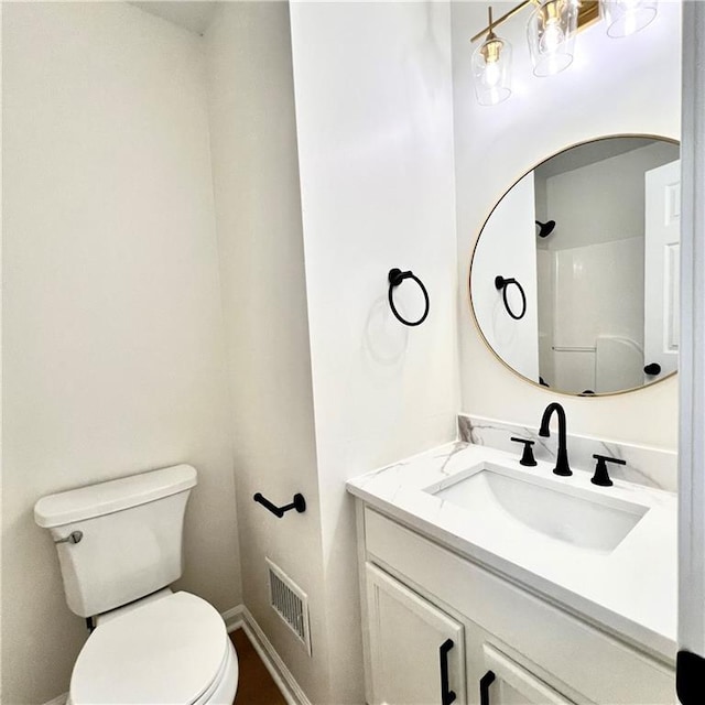 bathroom featuring vanity, toilet, baseboards, and visible vents