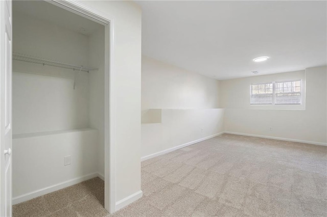 interior space featuring a spacious closet, carpet flooring, baseboards, and a closet