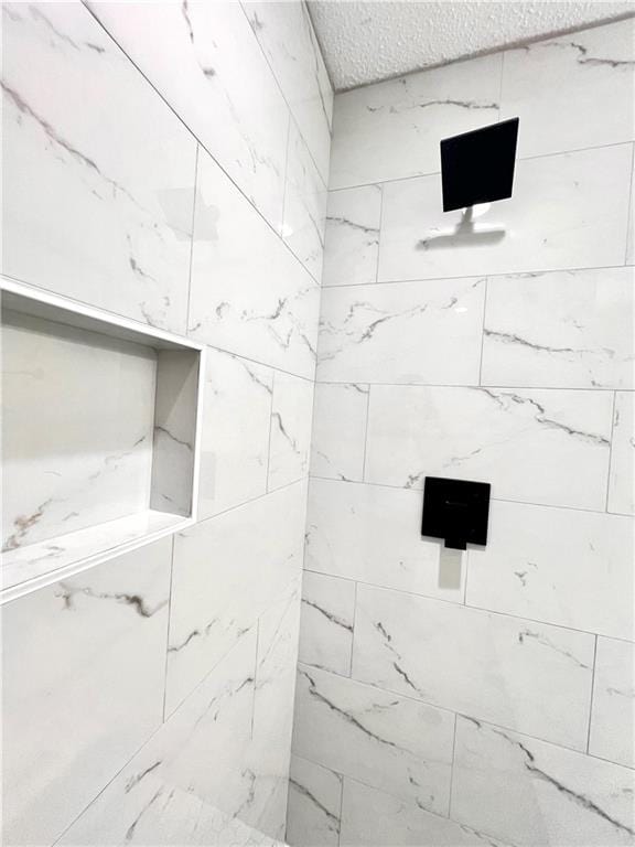 interior details with tiled shower and a textured ceiling