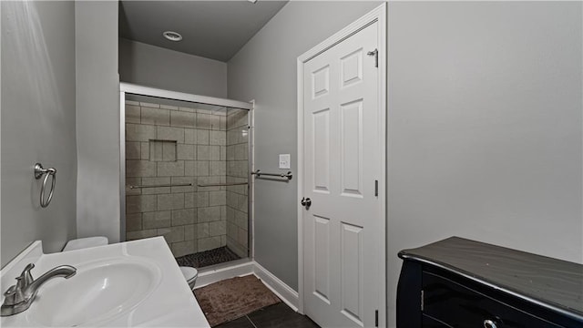 bathroom with a sink, toilet, a shower stall, and tile patterned floors