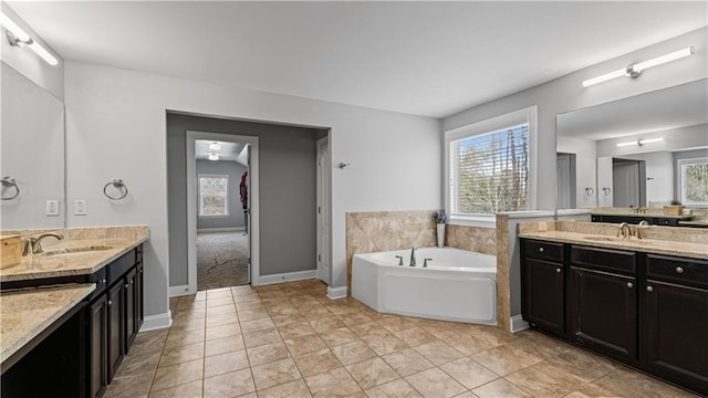 full bathroom featuring a bath, a healthy amount of sunlight, and a sink