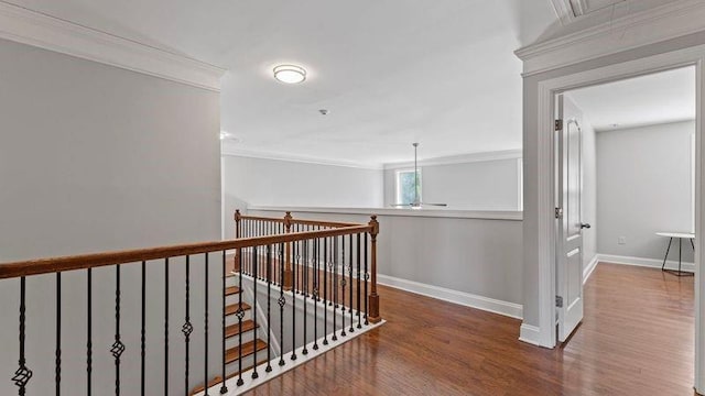 hallway with ornamental molding, attic access, baseboards, and wood finished floors