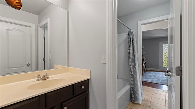 full bath with tile patterned floors, baseboards, shower / tub combo, and vanity