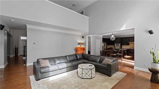 living room with a high ceiling, wood finished floors, and baseboards