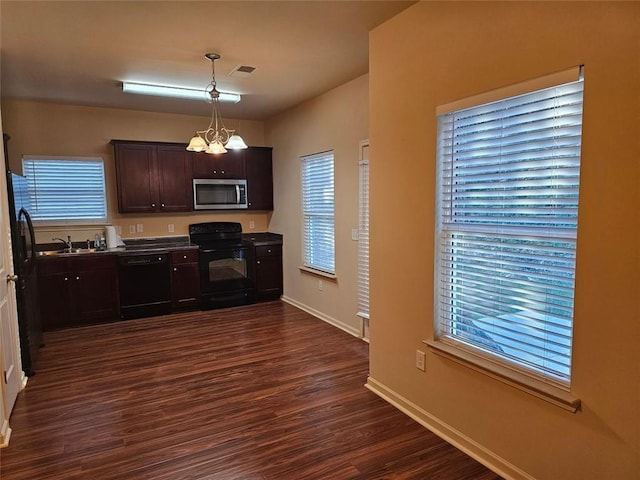 kitchen with a chandelier, a wealth of natural light, black appliances, and dark hardwood / wood-style floors