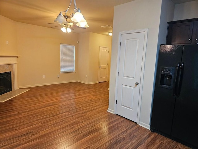 unfurnished living room featuring dark hardwood / wood-style flooring and ceiling fan with notable chandelier